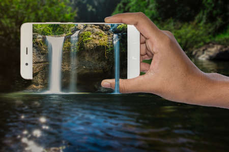 3D Pop Up Waterfall hand holding mobile phoneの写真素材