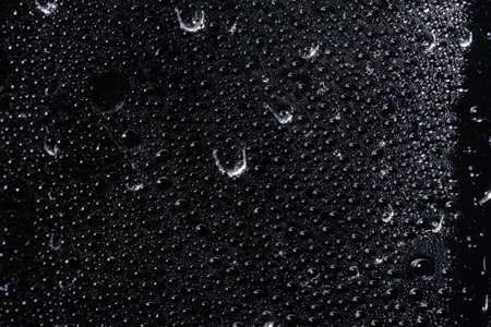 Macro droplet on transparent plastic sheet, black backgroundの写真素材