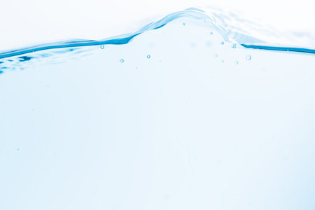Surface of the blue water waves splash on a white background