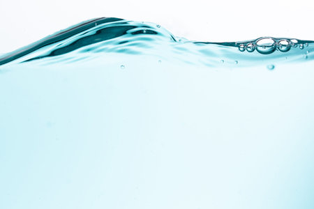 Surface of the blue water waves splash on a white background