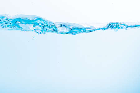 Surface of the blue water waves splash on a white backgroundの写真素材
