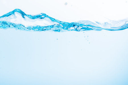 Surface of the blue water waves splash on a white backgroundの写真素材