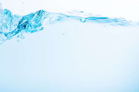Surface of the blue water waves splash on a white backgroundの写真素材