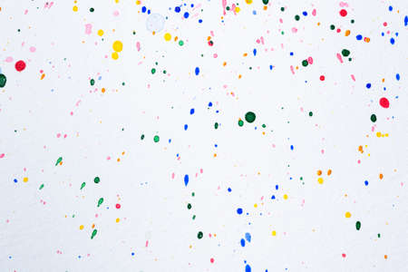 A variety of watercolor droplets on white paperの写真素材