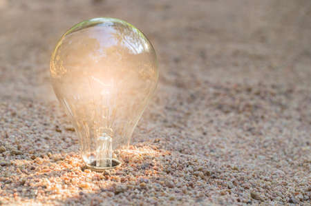 Light bulb Laying on the sand Natural energy conceptの写真素材
