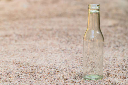 Empty glass bottles on the sand Concept of garbage pollutionの写真素材