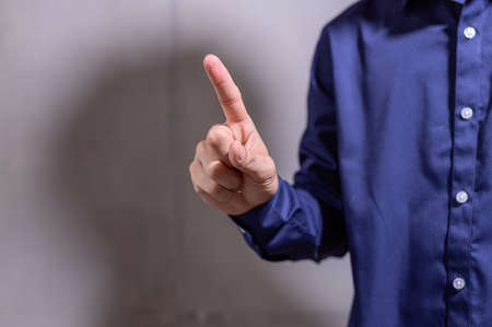 A business man pointing a finger in a blue shirtの写真素材