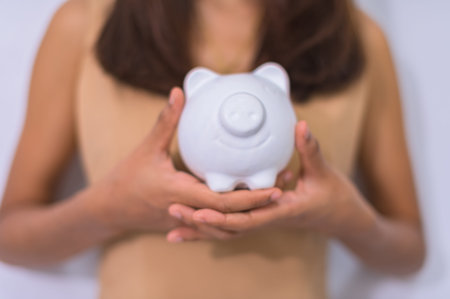 Concept of saving money business woman holding a piggy bank