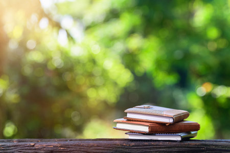 Notebook placed on a wooden background with bokeh Sun light