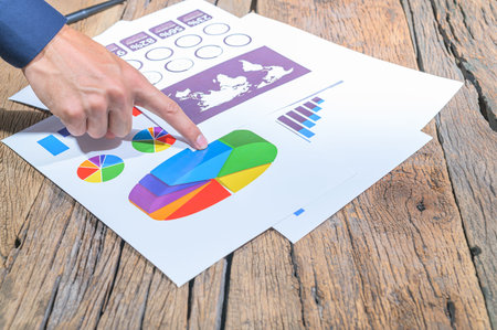 Hand pointing to the income graphの写真素材