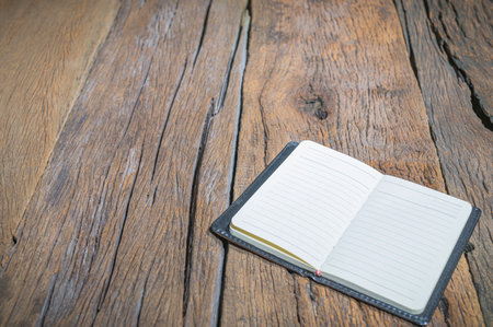 The notebook is placed on the wooden table