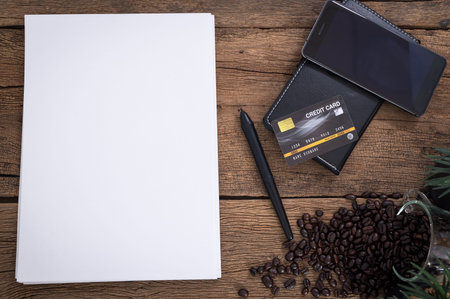 Credit card document smartphone coffee beans placed on a wooden table top view