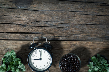 clock and a mug of coffee beans placed on the table top view