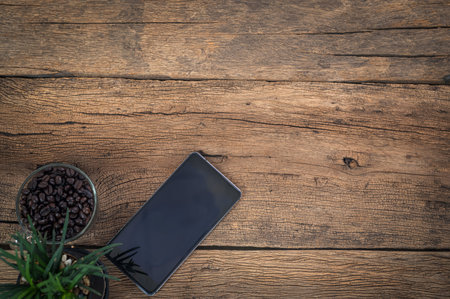 Smart phones coffee beans lying on a wooden table top viewの写真素材