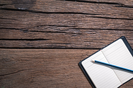 Notepad and pencil are on the desk, top view