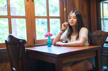 beautiful woman sitting in a chair in a cafeの写真素材