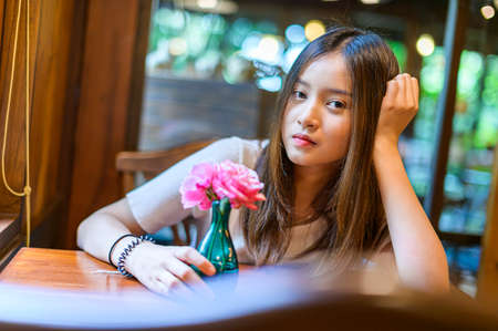 beautiful woman sitting in a chair in a cafeの写真素材
