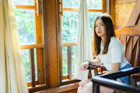 beautiful woman sitting on a chair in a cafeの写真素材