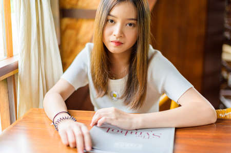 beautiful woman sitting in a cafe reading a bookの写真素材