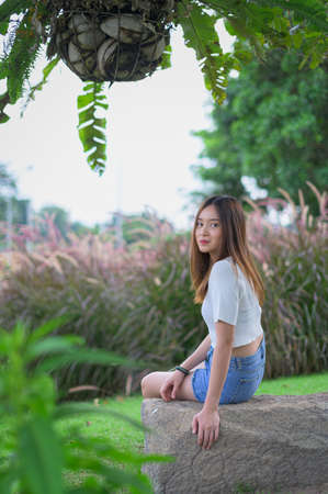 Beautiful women seats in the parkの写真素材