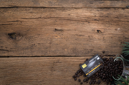 Credit card and coffee beans on the desk top view