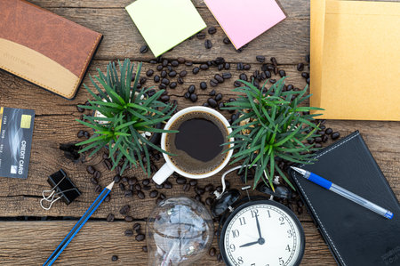 Mug coffee, paper, notebook, pencil, light bulb, clock at the desk, top view