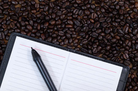 A notebook and pen on the coffee bean top viewの写真素材