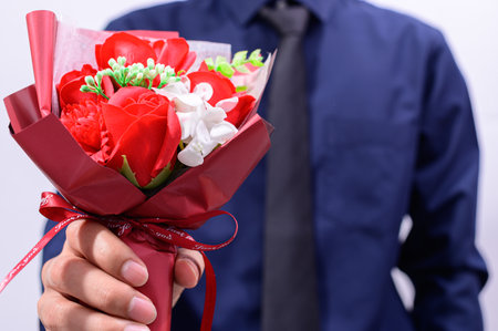 Men hold a bouquet of roses on valentine's dayの写真素材