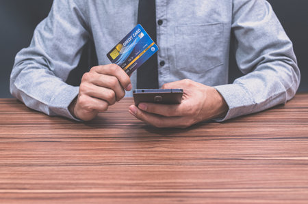 Businessmen use credit cards to shop online through smartphonesの写真素材