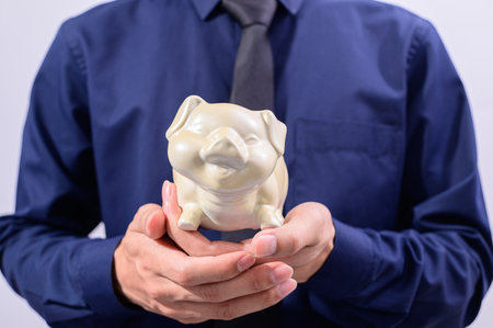 Man holding piggy bank money saving conceptの写真素材