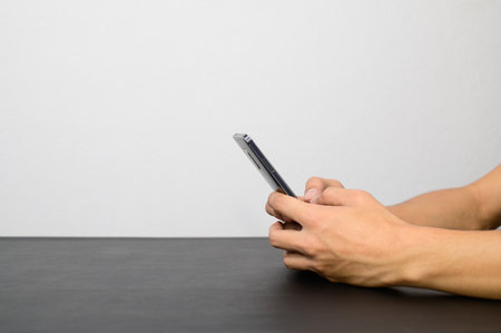 Hold your phone, use your smartphone at your deskの写真素材