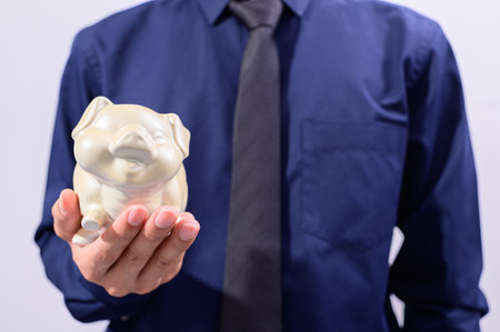 Man holding piggy bank money saving conceptの写真素材