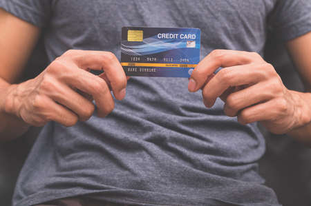 A man holding a credit card on his handの写真素材