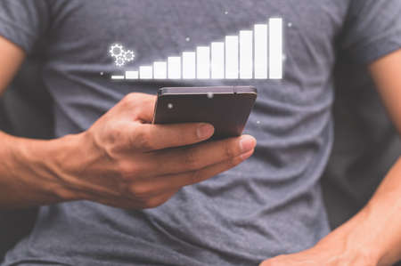 Business people use smartphones to show business growth graphの写真素材