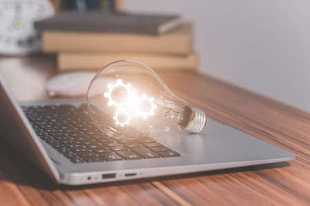 The gear symbol light bulb is on the computer.の写真素材