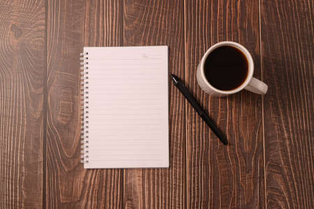 Coffee and a notebook are at your desk.の写真素材