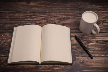 The notebook and a glass of milk are on the desk.