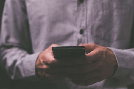 People using smartphones with dark tones.の写真素材