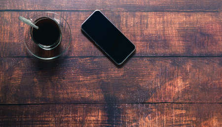Coffee cup, smartphone on the deskの写真素材