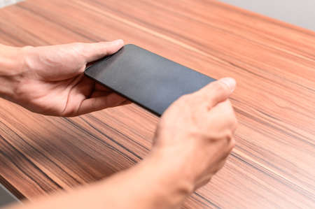 hand using smartphone at the deskの写真素材