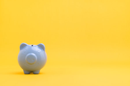 Piggy bank saving money against yellow backgroundの写真素材