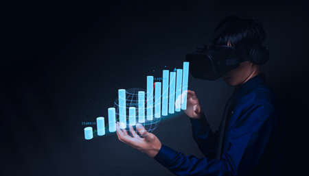 Businessman using Virtual Reality Metaverse glasses to virtual world showing bar graph business growthの写真素材