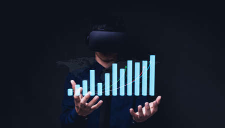 Businessman using Virtual Reality Metaverse glasses to virtual world showing bar graph business growthの写真素材