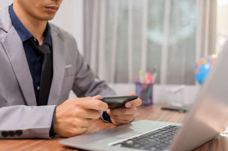 Businessmen are using mobile phones and smartphones to communicate and work.の写真素材