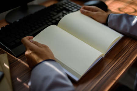 businessman reading and writing book at workの写真素材