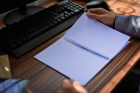 businessman reading and writing book at work