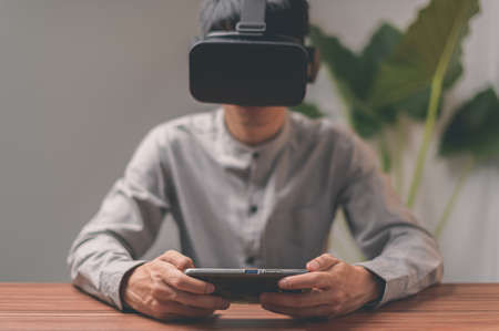 People are using smartphones to communicate, work, play games, watch movies through VR glasses.の写真素材