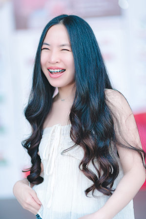 Beautiful Asian woman poses in fashion style, white shirt, jeans skirt.
