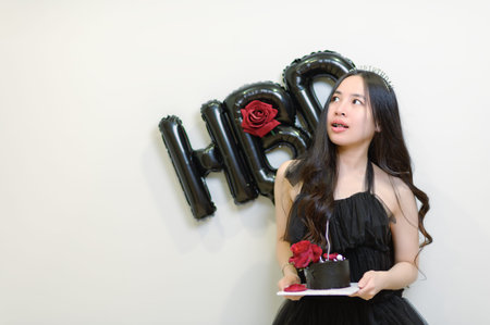 Beautiful woman wearing a black dress and chocolate cake in the concept of birthday
