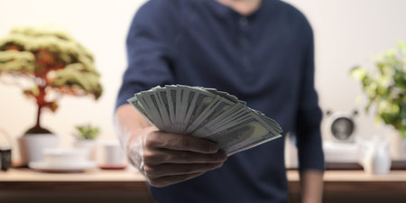 Businessman holding banknotes, investing in stocks, buying and selling goods, income, expenses,...